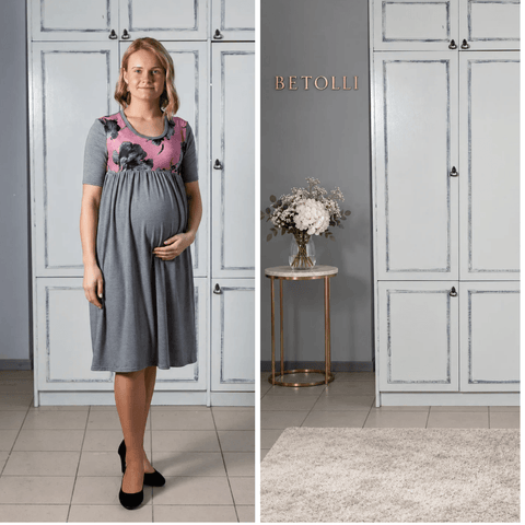 Model wearing the BETOLLI Simply Marija grey jersey maternity dress with a pink floral bodice, short sleeves and a gathered empire-waist skirt.